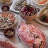 Restaurante La Alacena de Francis en Málaga ofrece una vibrante selección de platos, con ensaladas frescas, exquisitos mariscos y una creación bellamente en capas adornada con hierbas y verduras. - ForTwo - Planes para parejas