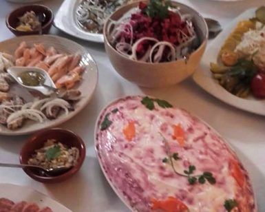 Restaurante La Alacena de Francis en Málaga ofrece una vibrante selección de platos, con ensaladas frescas, exquisitos mariscos y una creación bellamente en capas adornada con hierbas y verduras. - ForTwo - Planes para parejas
