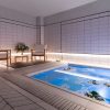 Experimente la serenidad en el moderno spa del Gran Hotel Inglés, con una piscina hundida y sillas de madera sobre paredes de azulejos blancos. La suave iluminación crea el ambiente perfecto para un relajante cóctel con acceso a jacuzzi y masaje en el Gran Hotel Inglés (Madrid). Disfrute de la tranquilidad. - ForTwo - Planes para parejas