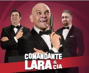 Tres hombres de esmoquin, haciéndose pasar por espías con pistolas de juguete sobre un vibrante fondo rojo, prepararon el escenario para una noche inolvidable en Madrid. El texto dice: Comandante Lara & Cía - Sala Capitol (Madrid). - ForTwo - Planes para parejas