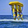 Dos personas viajan en un inflable amarillo y azul en el "Salta por los aires sobre el mar practicando el Flyfish en Barcelona" sobre el mar resplandeciente cerca de Barcelona. - ForTwo - Planes para parejas