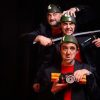 En el exterior del Teatro EDP Gran Vía de Madrid, tres hombres con casco posan dramáticamente con armas y un paquete de dinamita, evocando una escena de "Corta el cable rojo". - ForTwo - Planes para parejas