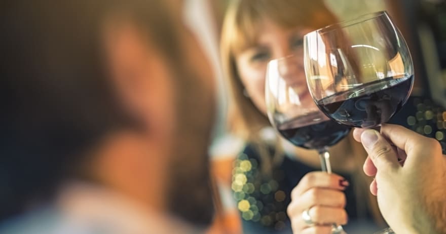 Dos personas brindando con vino tinto en un ambiente cálido y luminoso, dirigidos por un experto sumiller durante el "Curso de cata de vinos con un experto sumiller" en Madrid. - ForTwo - Planes para parejas