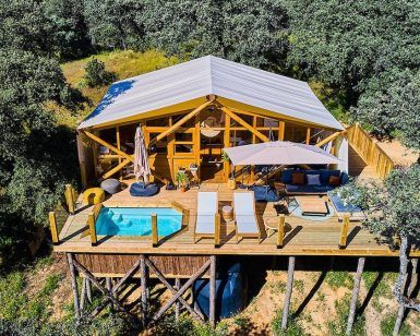 Vista aérea de la Cabaña junior suite con piscina privada en La Dehesa Experiences (Córdoba) que muestra una piscina privada, terraza y sillas de descanso en medio de árboles para un refugio exclusivo. - ForTwo - Planes para parejas