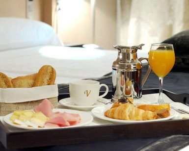 Datos del producto: Disfrute de una escapada matutina en el Hotel Vincci Frontaura con una bandeja de desayuno con café, zumo, cruasanes, pan, queso y jamón sobre una cama con almohadas blancas. Disfrute de la Escapada con cena en el Hotel Vincci Frontaura (Valladolid). - ForTwo - Planes para parejas