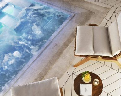 Un lujoso jacuzzi, dos sillas acolchadas y una pequeña mesa con un libro y una bebida sobre baldosas geométricas inspiradas en los elegantes años 20 crean el ambiente perfecto en Égoïste Spa. - ForTwo - Planes para parejas
