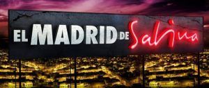 Un llamativo cartel con la leyenda "Ruta por el Madrid de Sabina" brilla sobre el resplandeciente paisaje urbano por la noche, capturando la energía vibrante de las bulliciosas calles de Madrid. - ForTwo - Planes para parejas