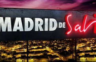 Un llamativo cartel con la leyenda "Ruta por el Madrid de Sabina" brilla sobre el resplandeciente paisaje urbano por la noche, capturando la energía vibrante de las bulliciosas calles de Madrid. - ForTwo - Planes para parejas