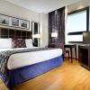 Experimente una comodidad inigualable en nuestra habitación bellamente decorada del Hotel Eurostars Gran Valencia, que cuenta con una cama doble con almohadas estampadas, pisos de madera, escritorio, TV y arte enmarcado en la pared. - ForTwo - Planes para parejas