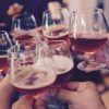 Primer plano de manos tintineando vasos de líquido ámbar durante un vibrante Taller de cata y degustación de cerveza en Barcelona. - ForTwo - Planes para parejas