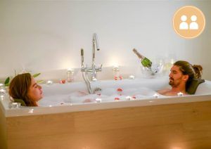 Una pareja se relaja con una "Experiencia premium" de 9sentits en Barcelona, disfrutando de un ambiente relajante que combina masaje corporal, baño y ambiente de sauna. - ForTwo - Planes para parejas