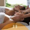 Una pareja disfruta de un "Masaje oriental en pareja en el barrio de Salamanca", envuelta en la serena atmósfera del spa, descansando en camillas de masaje cubiertas con suaves toallas. - ForTwo - Planes para parejas