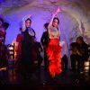 Los bailarines de flamenco actúan enérgicamente en el escenario con guitarristas de fondo, creando un electrizante "El Templo del Flamenco - Cena con espectáculo" en un entorno similar a una cueva. - ForTwo - Planes para parejas