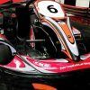 Un kart rojo y negro, con un número 6 en su capó, de la ¡Carrera de Karts en Fórmula Karting Granada!, está estacionado en una pista cubierta en Granada. - ForTwo - Planes para parejas