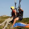 Dos personas despegan de una ladera cubierta de hierba en Bilbao para su "Vuelo en parapente biplaza o tándem para 2". Uno lleva un casco amarillo y el otro, uno negro, listos para la aventura. - ForTwo - Planes para parejas