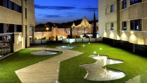 Experimente la tranquilidad en el moderno patio del hotel Sercotel Gran Luna de 4*, con estanques iluminados y senderos serpenteantes. Disfrute de una escapada tranquila con spa y gimnasio. - ForTwo - Planes para parejas