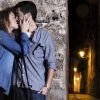 En la encantadora Granada, una pareja se besa contra un muro de piedra en una calle con poca luz por la noche, capturando el romance de "Un paseo de fotografía en pareja en Granada. - ForTwo - Planes para parejas