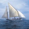La Garoinada a bordo de un velero de época en Palamós ofrece una pintoresca escena de grandes velas deslizándose en el océano bajo un cielo azul con nubes, capturando el encanto marítimo de la fiesta tradicional. - ForTwo - Planes para parejas