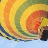 El Vuelo en Globo con Globotur en Sevilla ofrece una experiencia inolvidable mientras un vibrante globo aerostático con una cesta asciende con gracia contra el cielo azul claro. - ForTwo - Planes para parejas