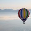 Un Vuelo estándar en globo por Cataluña con Globus (Barcelona) flota sobre los paisajes brumosos y las montañas distantes bajo un cielo despejado. - ForTwo - Planes para parejas