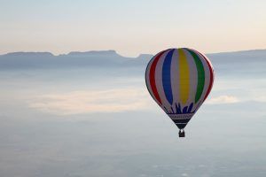 Un Vuelo estándar en globo por Cataluña con Globus (Barcelona) flota sobre los paisajes brumosos y las montañas distantes bajo un cielo despejado. - ForTwo - Planes para parejas