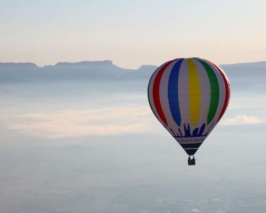 Un Vuelo estándar en globo por Cataluña con Globus (Barcelona) flota sobre los paisajes brumosos y las montañas distantes bajo un cielo despejado. - ForTwo - Planes para parejas
