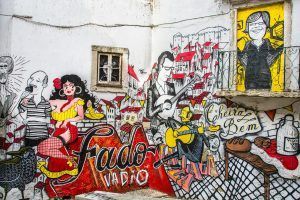 Vibrante mural que presenta músicos y cantantes de fado con instrumentos, capturando la esencia del Tour gratuito alternativo de Lisboa. - ForTwo - Planes para parejas