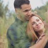 En una hermosa imagen de la "Sesión de fotografía en pareja por Carlos Fierro", una pareja se abraza en un campo de hierba, la mujer levanta alegremente su mano. - ForTwo - Planes para parejas