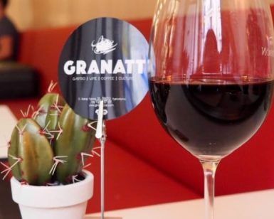 En Granatti en Gràcia, conocido por su "Maridaje de arroz y vino", una copa de vino complementa un pequeño cactus en la mesa, con asientos rojos que se suman al ambiente acogedor. - ForTwo - Planes para parejas
