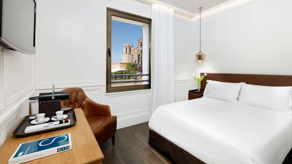 Disfrute de una escapada en el H10 Montcada, Barcelona, con una acogedora cama, cafetera, silla y vistas a la majestuosa catedral. - ForTwo - Planes para parejas