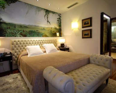 Cree un dormitorio inspirado en Ibiza con una cama con mechones acolchados, un mural de pared con motivos naturales y una iluminación moderna, haciendo eco de la elegancia del Hotel Mirador de Dalt Vila. - ForTwo - Planes para parejas