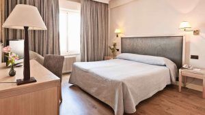 Relájese en una acogedora habitación del Hotel Príncipe Pío con cama doble, escritorio y lámpara. Los tonos neutros y el suelo de madera aportan tranquilidad. Después de explorar la ciudad, disfrute de una "Escapada al Hotel Príncipe Pío con botella de cava y cena en un restaurante a elegir (Madrid)" para completar la velada. - ForTwo - Planes para parejas