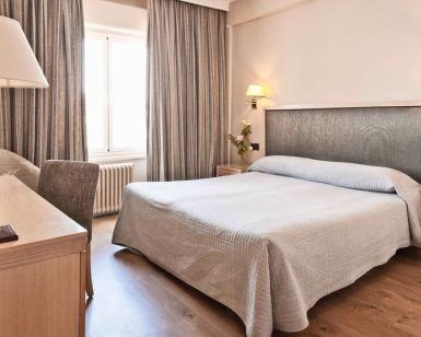 Relájese en una acogedora habitación del Hotel Príncipe Pío con cama doble, escritorio y lámpara. Los tonos neutros y el suelo de madera aportan tranquilidad. Después de explorar la ciudad, disfrute de una "Escapada al Hotel Príncipe Pío con botella de cava y cena en un restaurante a elegir (Madrid)" para completar la velada. - ForTwo - Planes para parejas