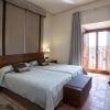 El Parador de Cáceres ofrece un acogedor alojamiento con dos camas individuales, mesitas de noche, TV de pared y un gran ventanal con cortinas que se abre a un encantador balcón. - ForTwo - Planes para parejas