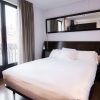 Disfrute de una estancia de ensueño en el Hotel Petit Palace, Bilbao. Esta elegante habitación incluye una cómoda cama doble con sábanas blancas, un cabecero oscuro y un gran espejo. Las ventanas con cortinas realzan la sensación de amplitud, complementando a la perfección el cálido suelo de madera. - ForTwo - Planes para parejas