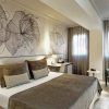Disfrute de la escapada perfecta en una habitación moderna del Hotel Escapada Sallés Pere IV de Barcelona, con una cama grande, arte floral, un cómodo sillón, lámpara y ventanas con cortinas transparentes que dejan entrar la luz natural. El paquete incluye desayuno, acceso al spa y bebida de bienvenida. - ForTwo - Planes para parejas