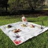 Picnic en Barcelona - Menú InCity: Un encantador picnic sobre un exuberante césped con un mantel blanco, pan, fruta, ensalada y vino tinto. Una bolsa parcialmente visible sugiere que nos esperan más delicias culinarias. - ForTwo - Planes para parejas