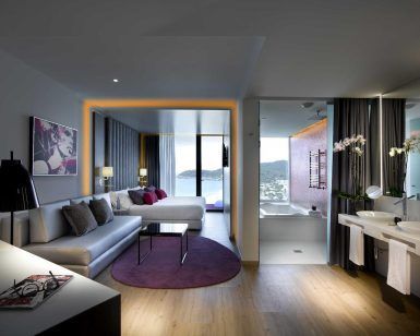 Disfrute de un moderno refugio en el Hard Rock Hotel (Ibiza) con una cama grande, un cómodo sofá y un baño abierto. Deléitese con las vistas al mar y a la montaña mientras se sumerge en su vibrante estilo icónico. - ForTwo - Planes para parejas