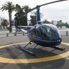 Un "Vuelo en helicóptero sobre el sur de Granada" en azul descansa sobre un helipuerto iluminado por el sol, envuelto por palmeras ondulantes y edificios de la ciudad, capturando la esencia vibrante de la región. - ForTwo - Planes para parejas