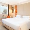 Alójese en el Hotel Hilton de Barcelona y disfrute de una experiencia moderna con una cama grande, elegantes mesitas de noche y una mesa redonda con una planta. Disfrute de las vibrantes vistas de la ciudad desde su ventana, capturando la esencia de este icónico destino. - ForTwo - Planes para parejas