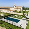 Vista aérea de la Estancia en la Abadía Retuerta LeDomaine (Valladolid), que muestra una villa con piscina, tumbonas y exuberantes jardines con un telón de fondo montañoso. - ForTwo - Planes para parejas