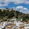 Con vistas a un conjunto de casas blancas en las colinas de Málaga, el castillo medieval ofrece una vista que recuerda las impresionantes vistas del Hotel Castillo de Monda. - ForTwo - Planes para parejas