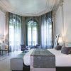Descubra una estancia refinada en Hospes Palacio de los Patos con una elegante habitación con una cama grande, decoración moderna, TV, escritorio y zona de estar junto a ventanales. Eleva tu experiencia con "Disfruta de un fin de semana de lujo con spa en Hospes Palacio de los Patos (Granada). - ForTwo - Planes para parejas
