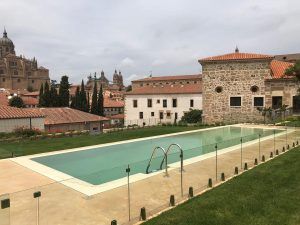 Experimente la Escapada romántica en el Palacio de San Esteban 5 estrellas en Salamanca. Escápese a la piscina exterior con acristalamiento, rodeada de históricos edificios de piedra y torres de catedral, creando un ambiente romántico perfecto para una escapada inolvidable. - ForTwo - Planes para parejas