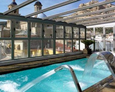 Descubra el encanto de Escapada, un hotel de cinco estrellas con spa (Alicante), que cuenta con una piscina cubierta con chorros de agua bajo un techo de cristal, impresionantes vistas a lugares históricos y una estructura en la cima de una colina, y un spa indulgente para el retiro de relajación perfecto. - ForTwo - Planes para parejas
