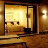 Relájese en una acogedora habitación de hotel con cama doble, con vistas a un patio con tumbonas y una mesa pequeña. Disfrute de la cálida iluminación mientras saborea un cóctel después de disfrutar de la Escapada con piscina, cóctel y visita guiada (Sevilla). - ForTwo - Planes para parejas