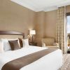 Disfrute del lujo en el Eurostars Palacio de Buenavista, Toledo. Disfrute de una cama king size con cojines decorativos, relájese en un cómodo sillón, trabaje en el escritorio y contemple las vistas a través de las elegantes cortinas desde su espaciosa habitación. - ForTwo - Planes para parejas