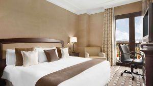 Disfrute del lujo en el Eurostars Palacio de Buenavista, Toledo. Disfrute de una cama king size con cojines decorativos, relájese en un cómodo sillón, trabaje en el escritorio y contemple las vistas a través de las elegantes cortinas desde su espaciosa habitación. - ForTwo - Planes para parejas