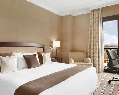 Disfrute del lujo en el Eurostars Palacio de Buenavista, Toledo. Disfrute de una cama king size con cojines decorativos, relájese en un cómodo sillón, trabaje en el escritorio y contemple las vistas a través de las elegantes cortinas desde su espaciosa habitación. - ForTwo - Planes para parejas
