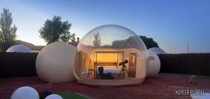 Al atardecer en un patio sereno, la Noche en hotel burbuja con telescopio en el Hotel Zielo Las Beatas ofrece una acogedora cama en una cúpula transparente y un telescopio para una experiencia de observación de estrellas inigualable. - ForTwo - Planes para parejas